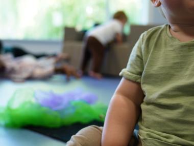 Barn sidder på gulvet